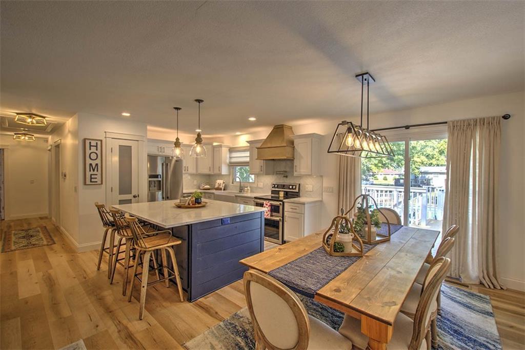 a view of a dining room and livingroom with furniture wooden floor a chandelier