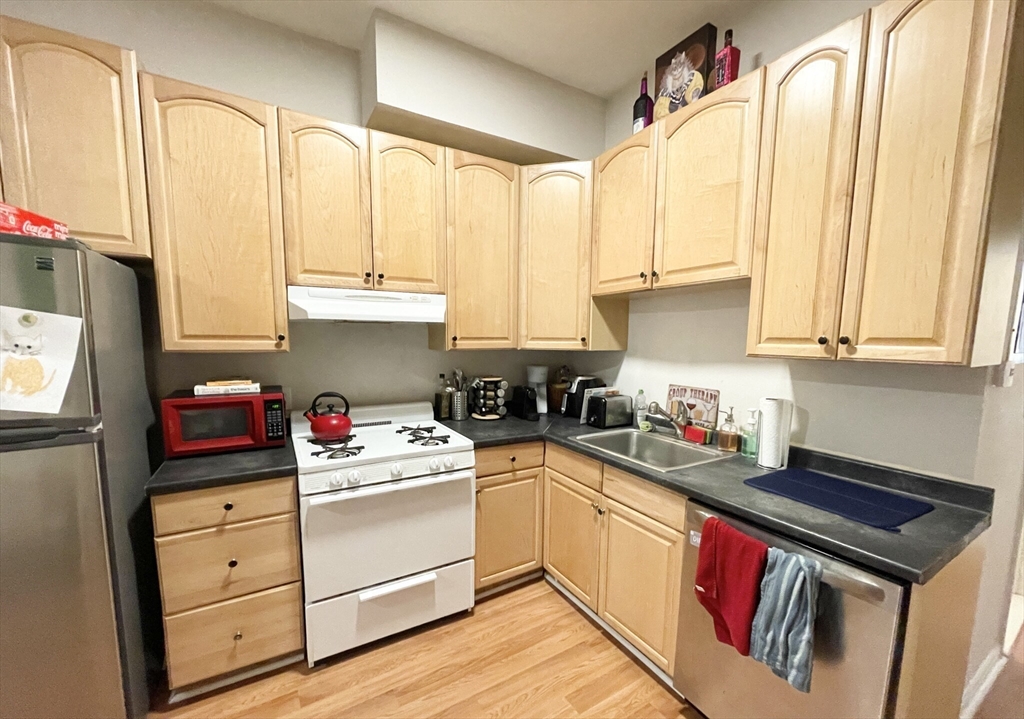 a kitchen with stainless steel appliances white cabinets and a stove top oven