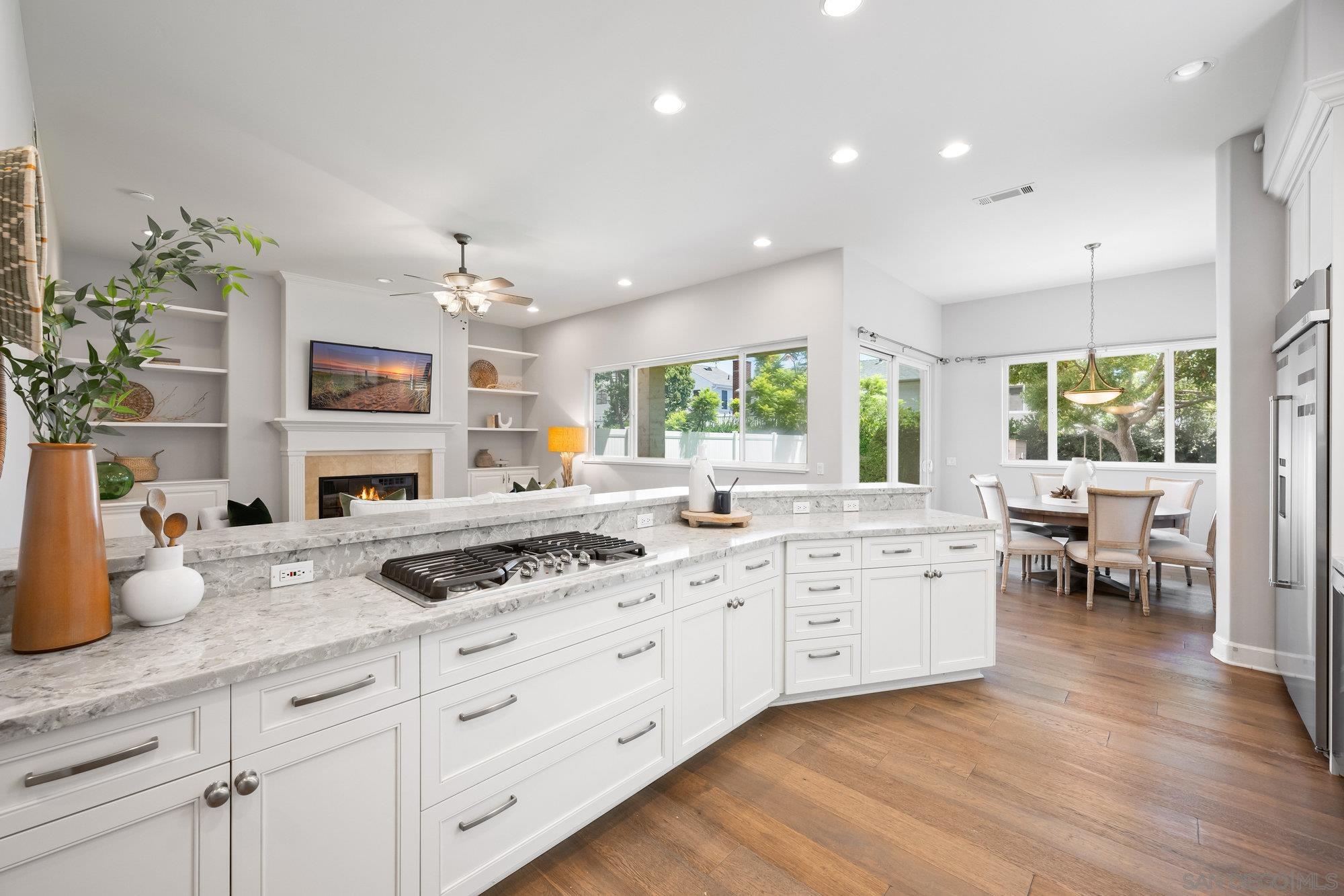 a kitchen with granite countertop a stove a sink a dining table and chairs