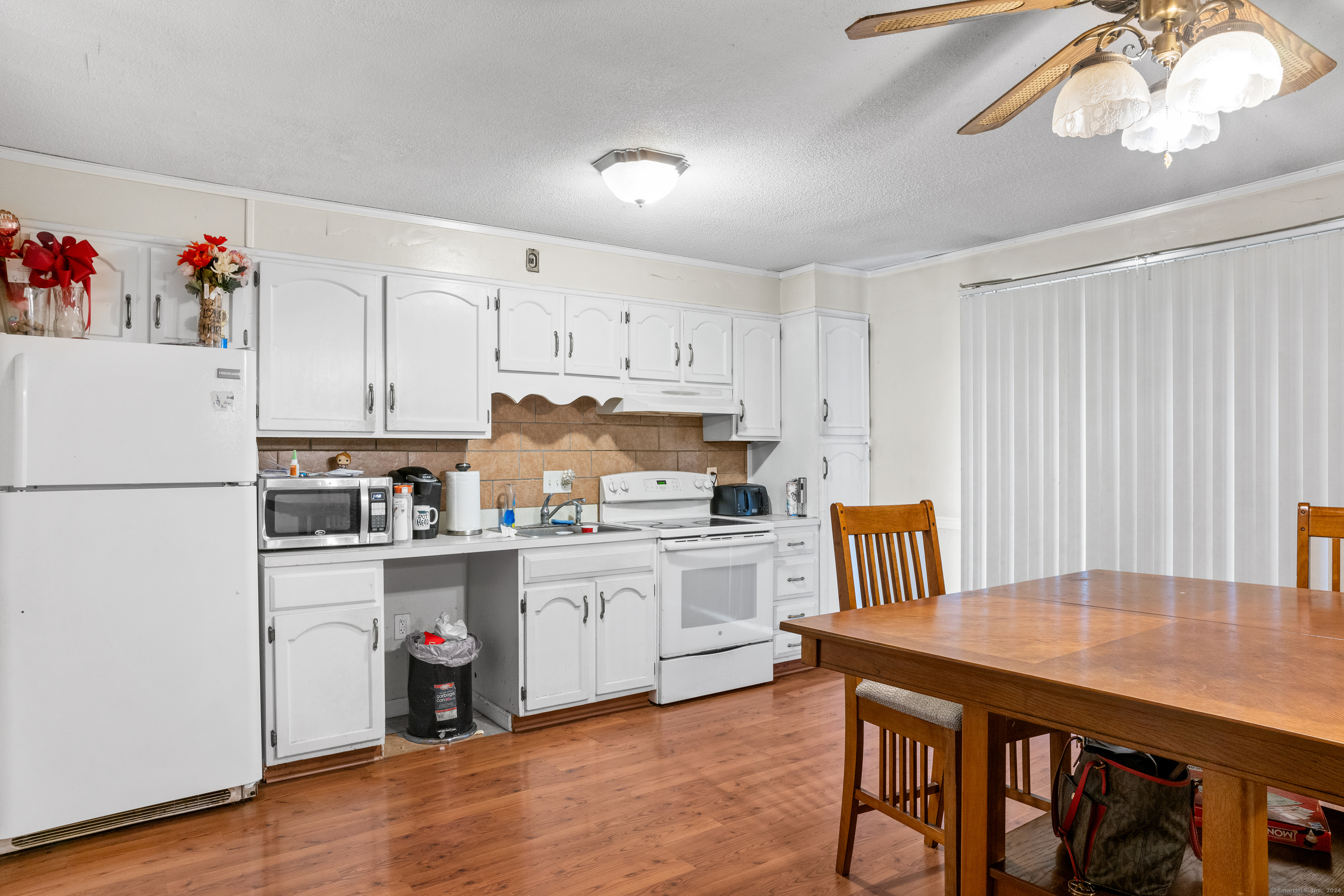 a kitchen with a table chairs refrigerator and cabinets