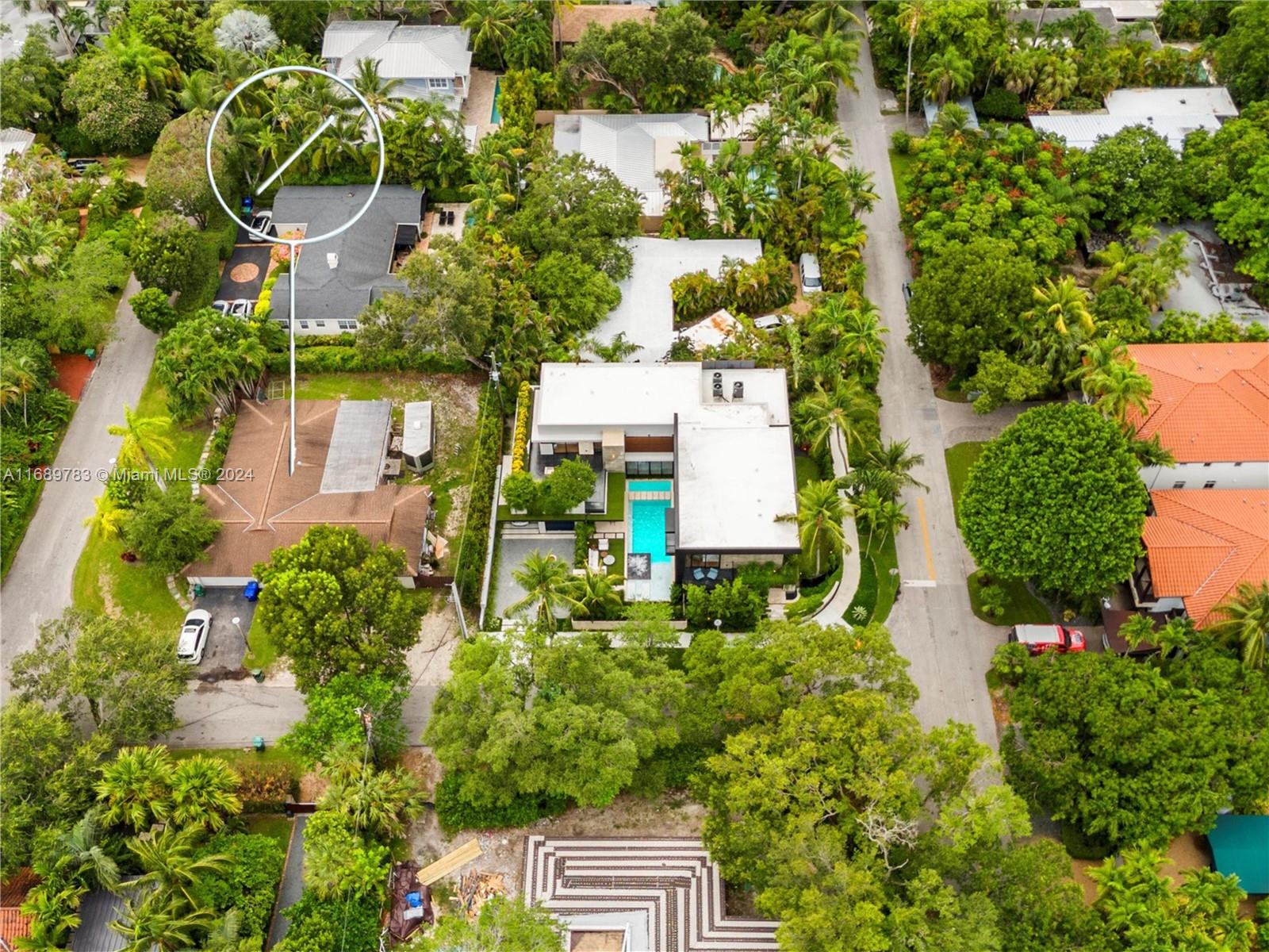 an aerial view of residential house with outdoor space and trees all around