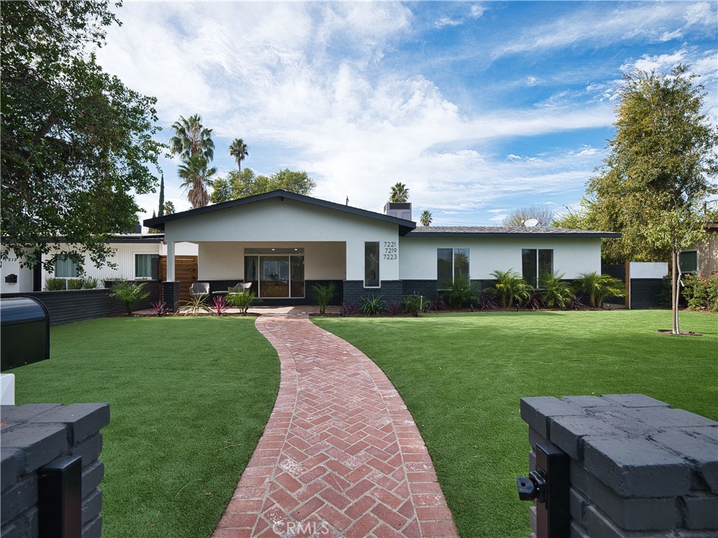 a front view of a house with a garden