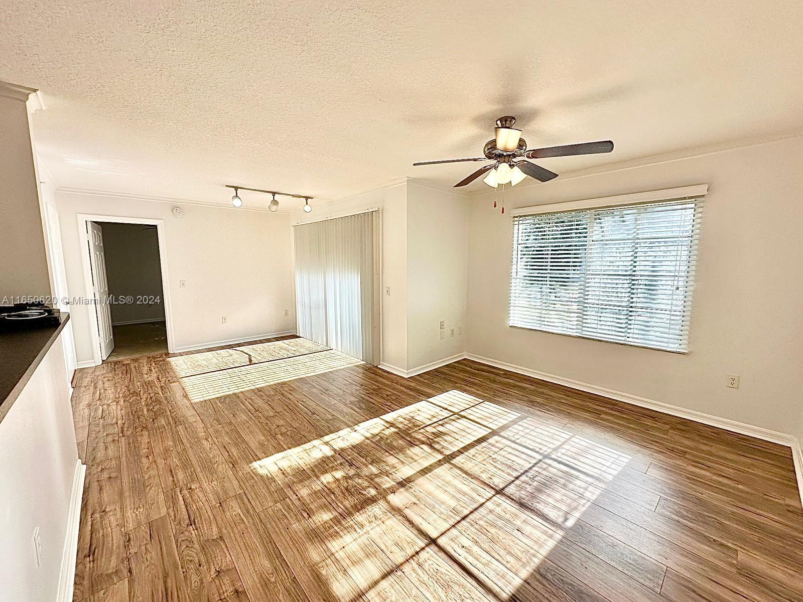 a view of a bedroom with wooden floor and a chandelier fan