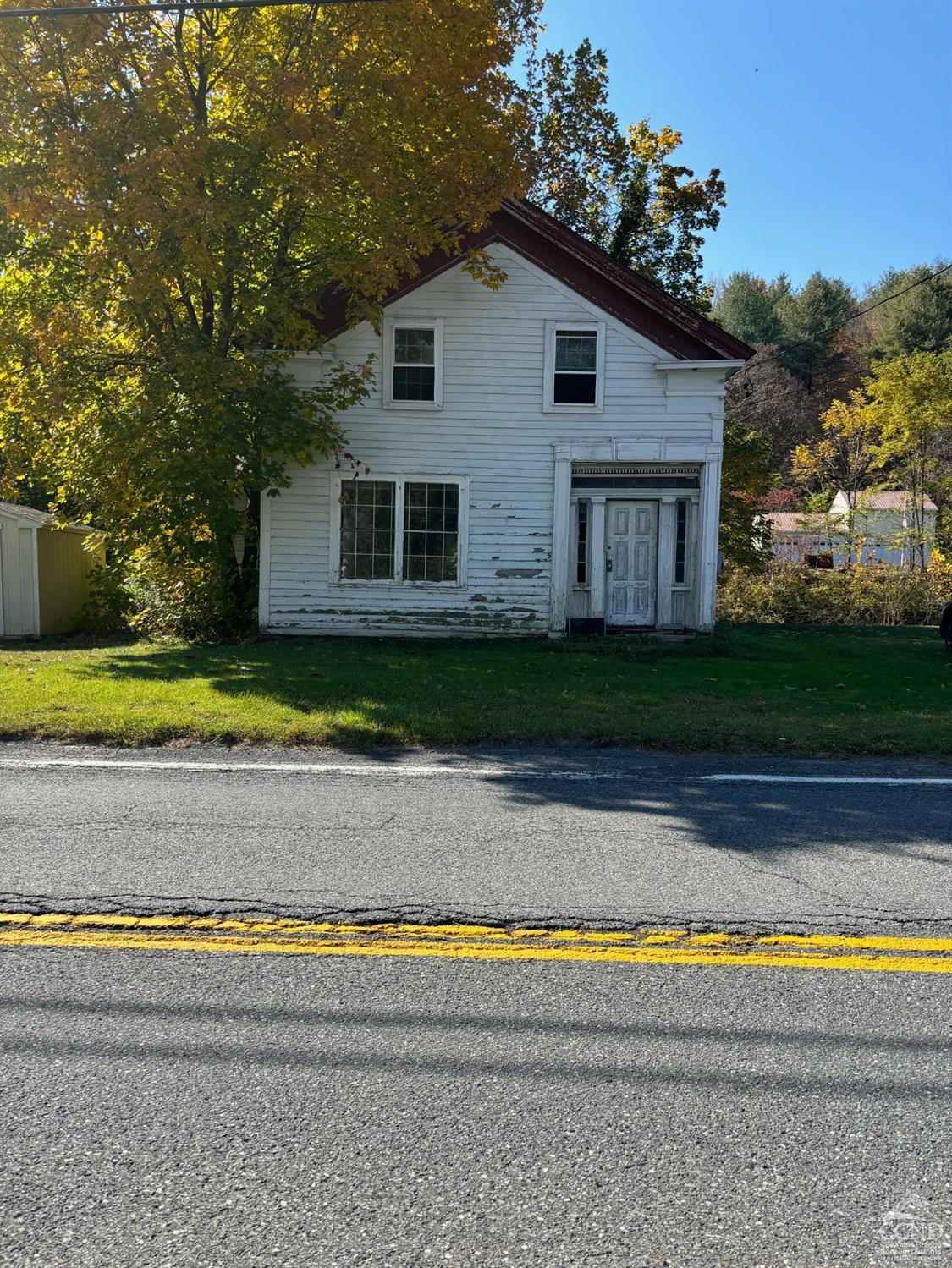 a view of a house with a yard and a large tree