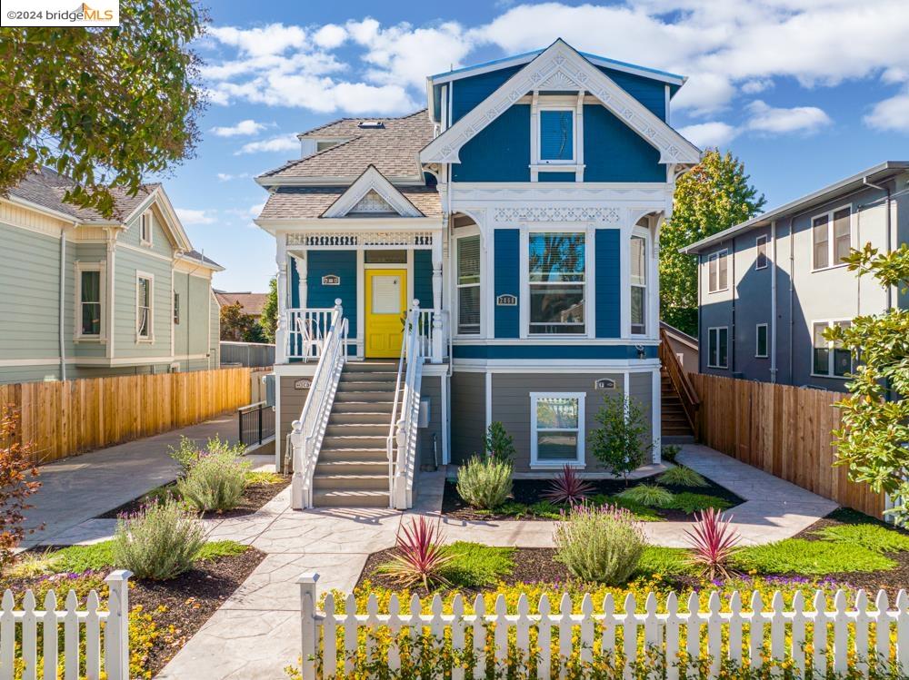 a view of a house with wooden fence next to a yard