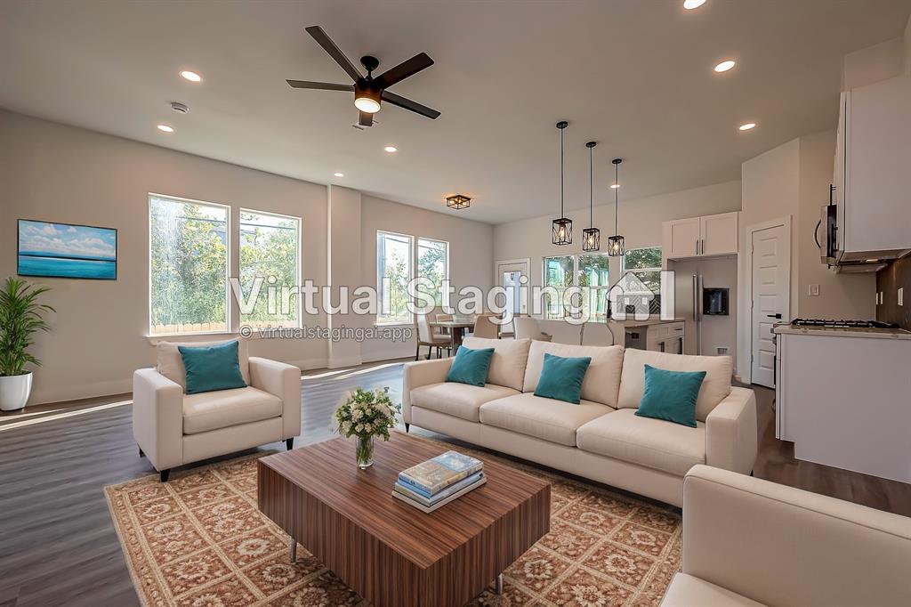 a living room with furniture ceiling fan and a large window