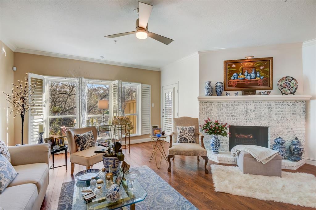 a living room with furniture a fireplace and a large window