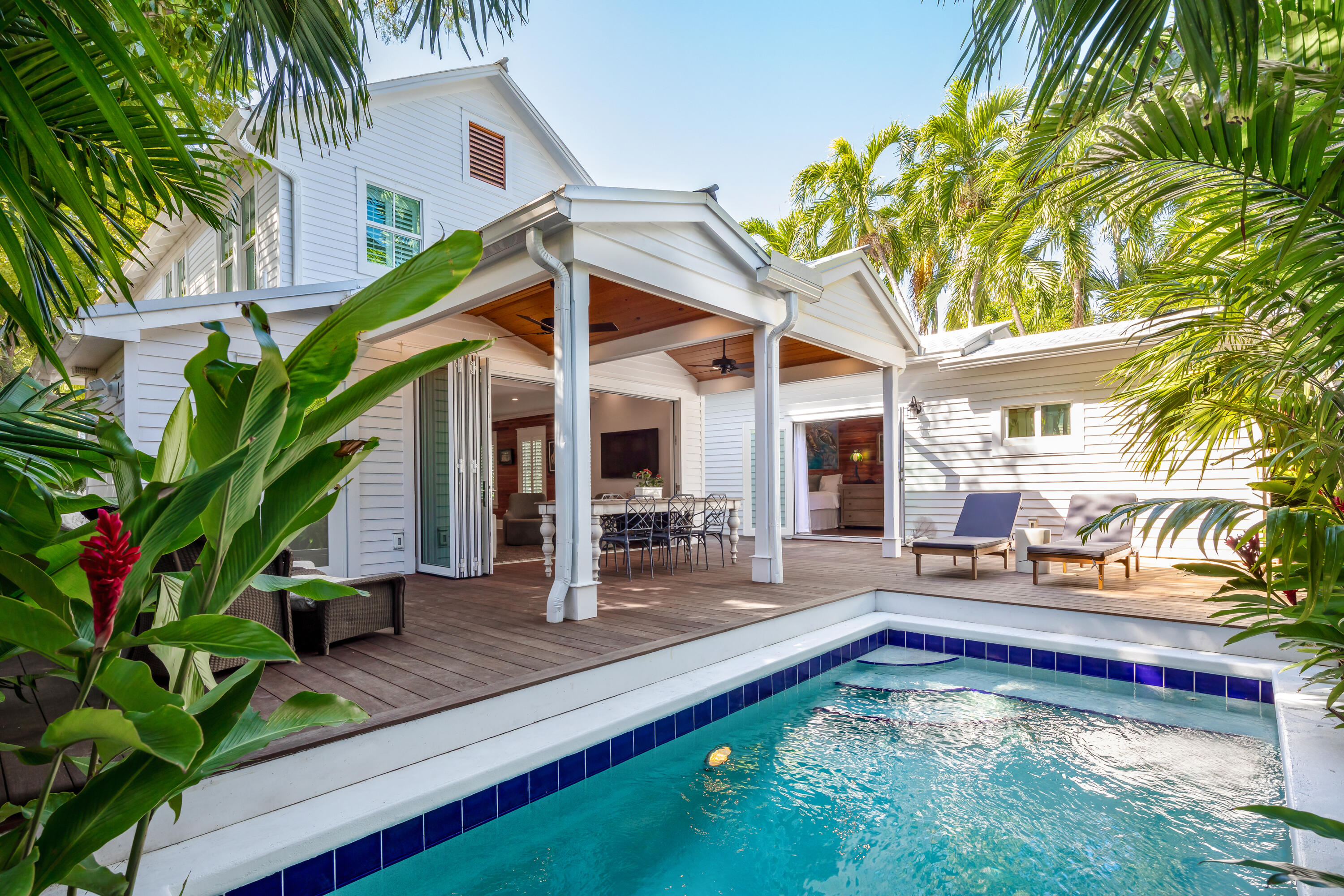 a view of a backyard with swimming pool table and chairs