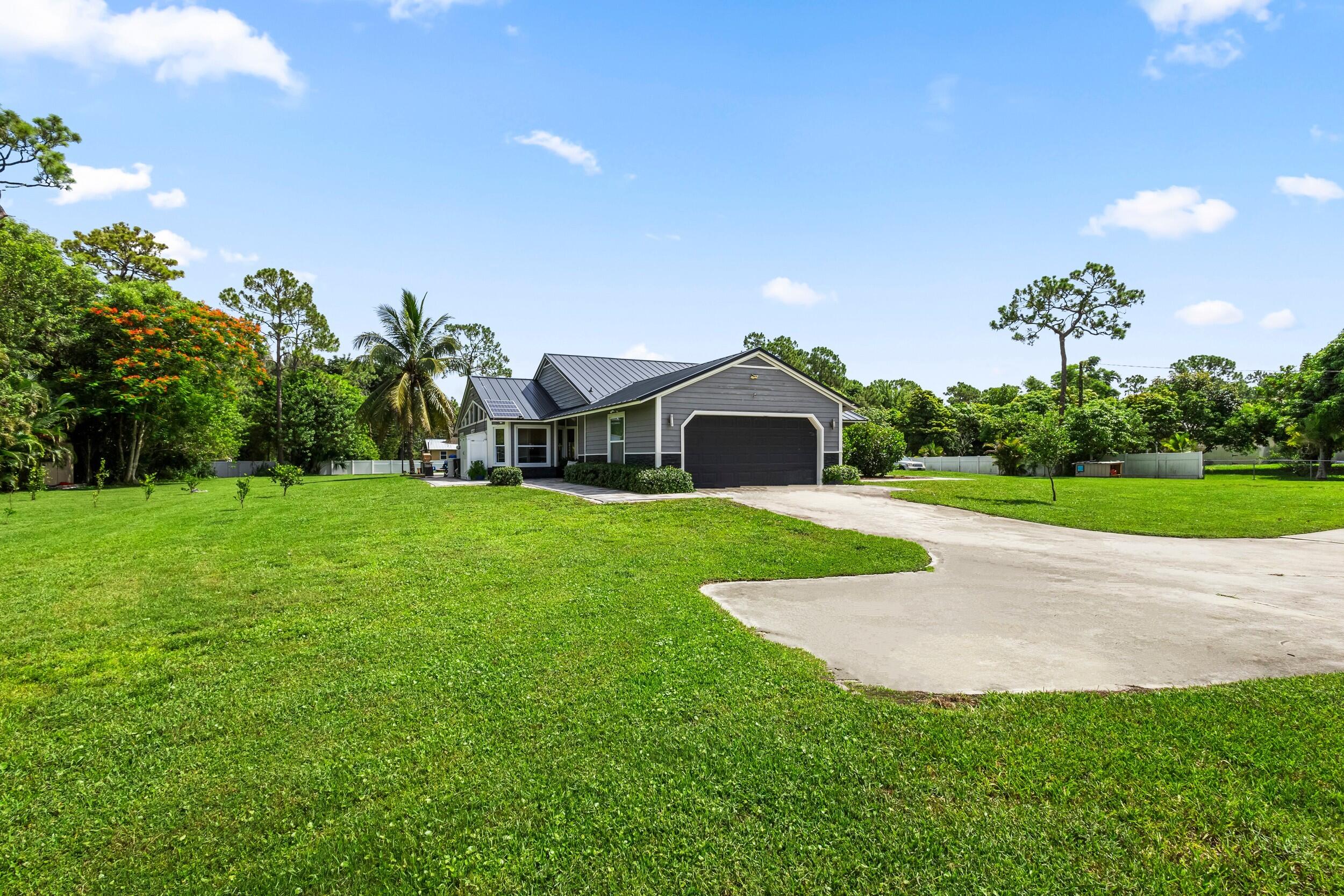 a view of house with garden and tall trees