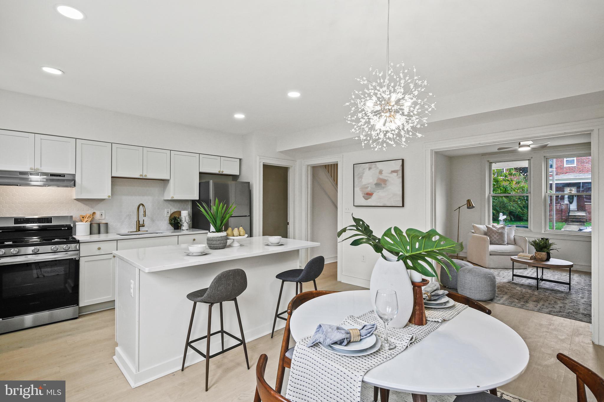 a kitchen with stainless steel appliances a table and chairs in it