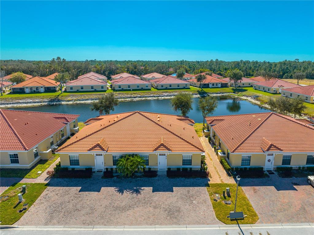 an aerial view of a house with swimming pool and lake view