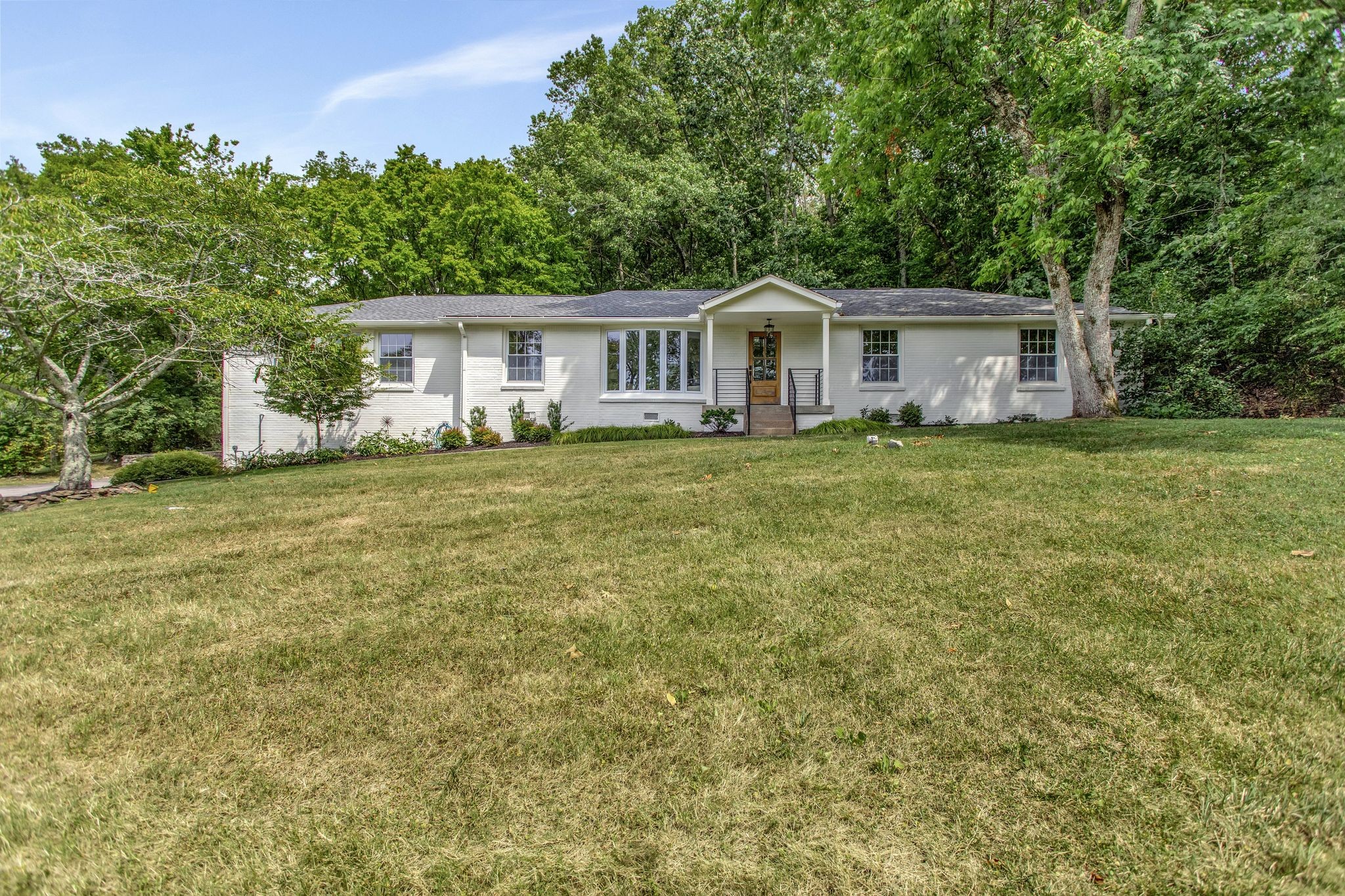 a front view of a house with a garden