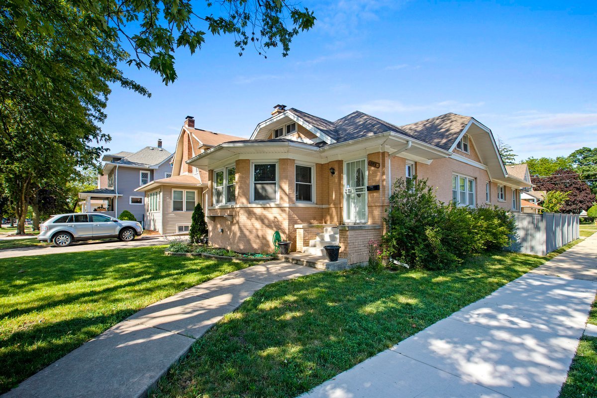 a front view of a house with a garden and yard