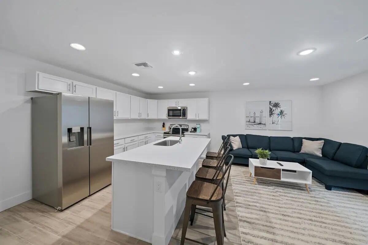 a kitchen with stainless steel appliances granite countertop a refrigerator and a stove top oven