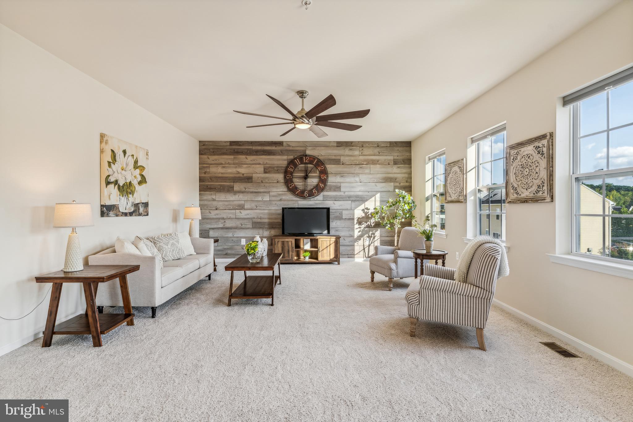 a living room with furniture a fireplace and a large window