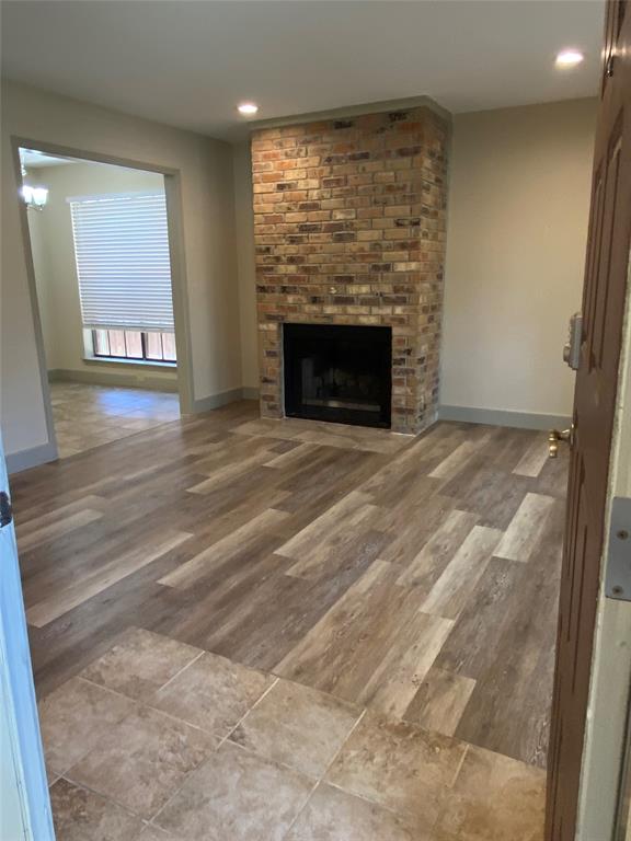 a view of an empty room with a fireplace and a window