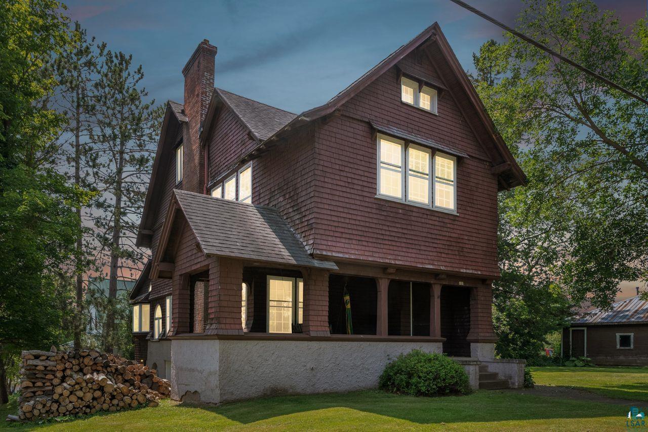 Back house at dusk with a yard