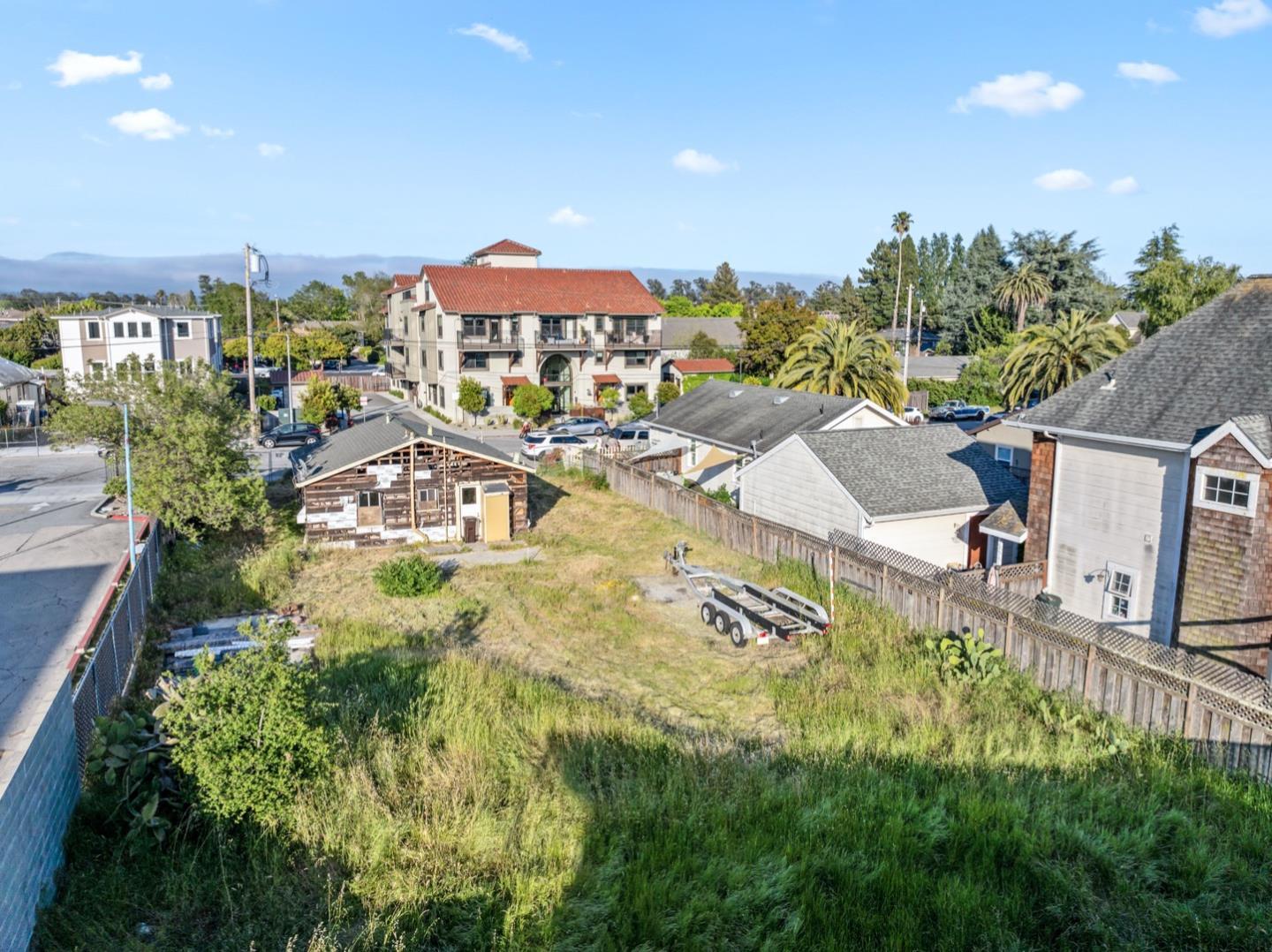 an aerial view of residential houses with outdoor space and trees