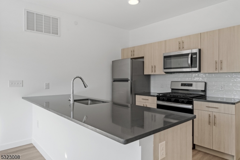 a kitchen with stainless steel appliances granite countertop a sink and a microwave