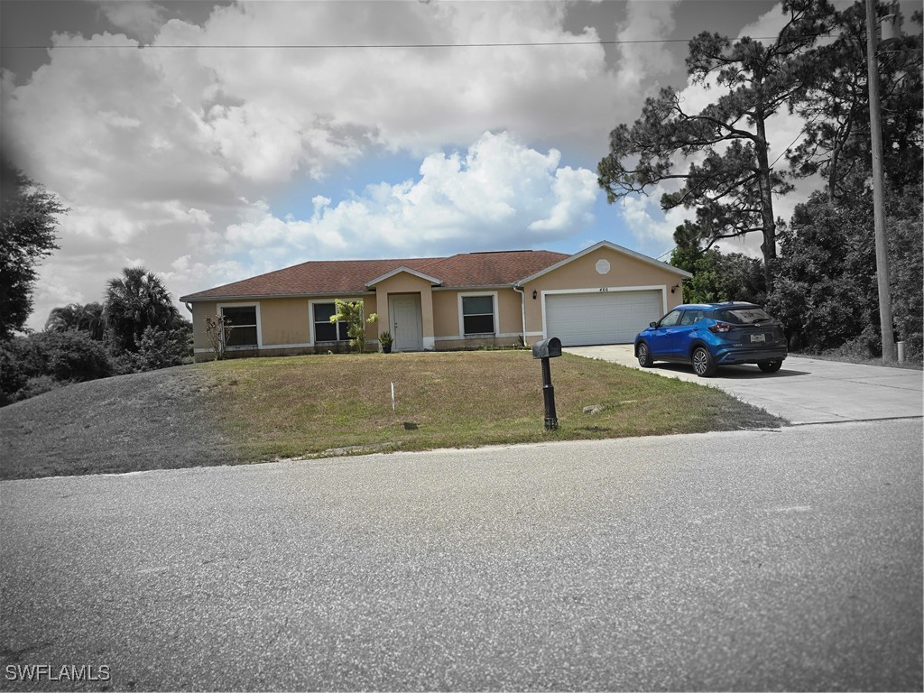 a view of a house with a yard and large trees