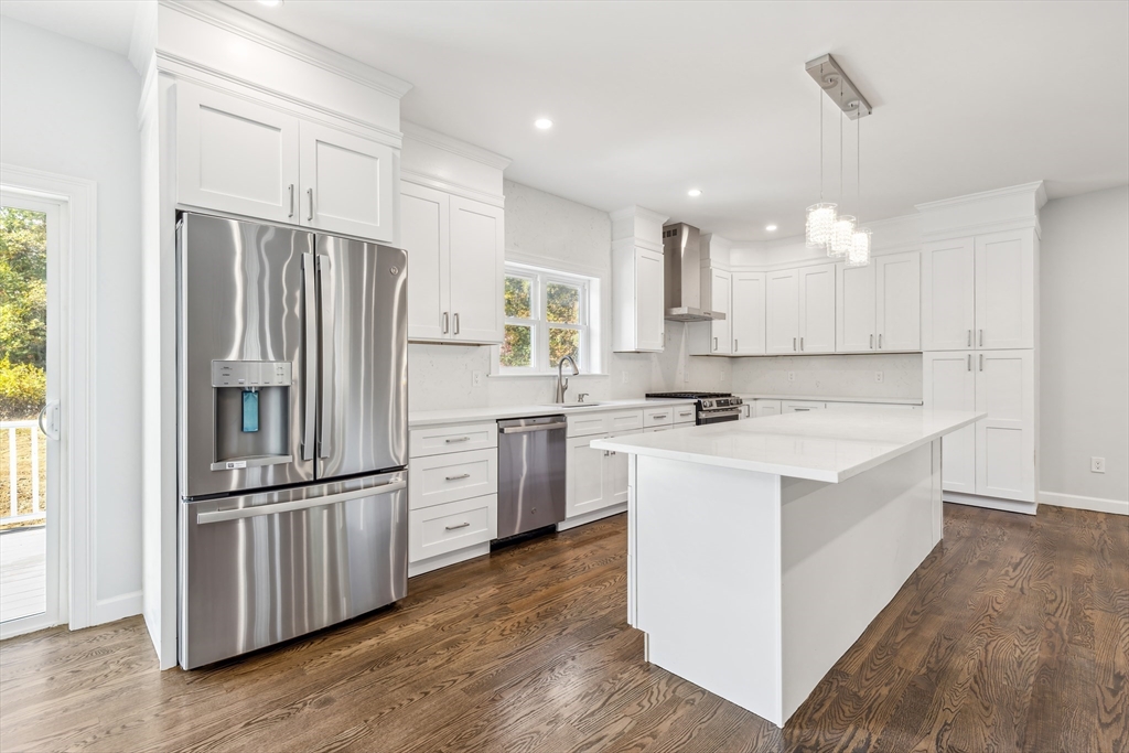 a kitchen with kitchen island white cabinets and stainless steel appliances