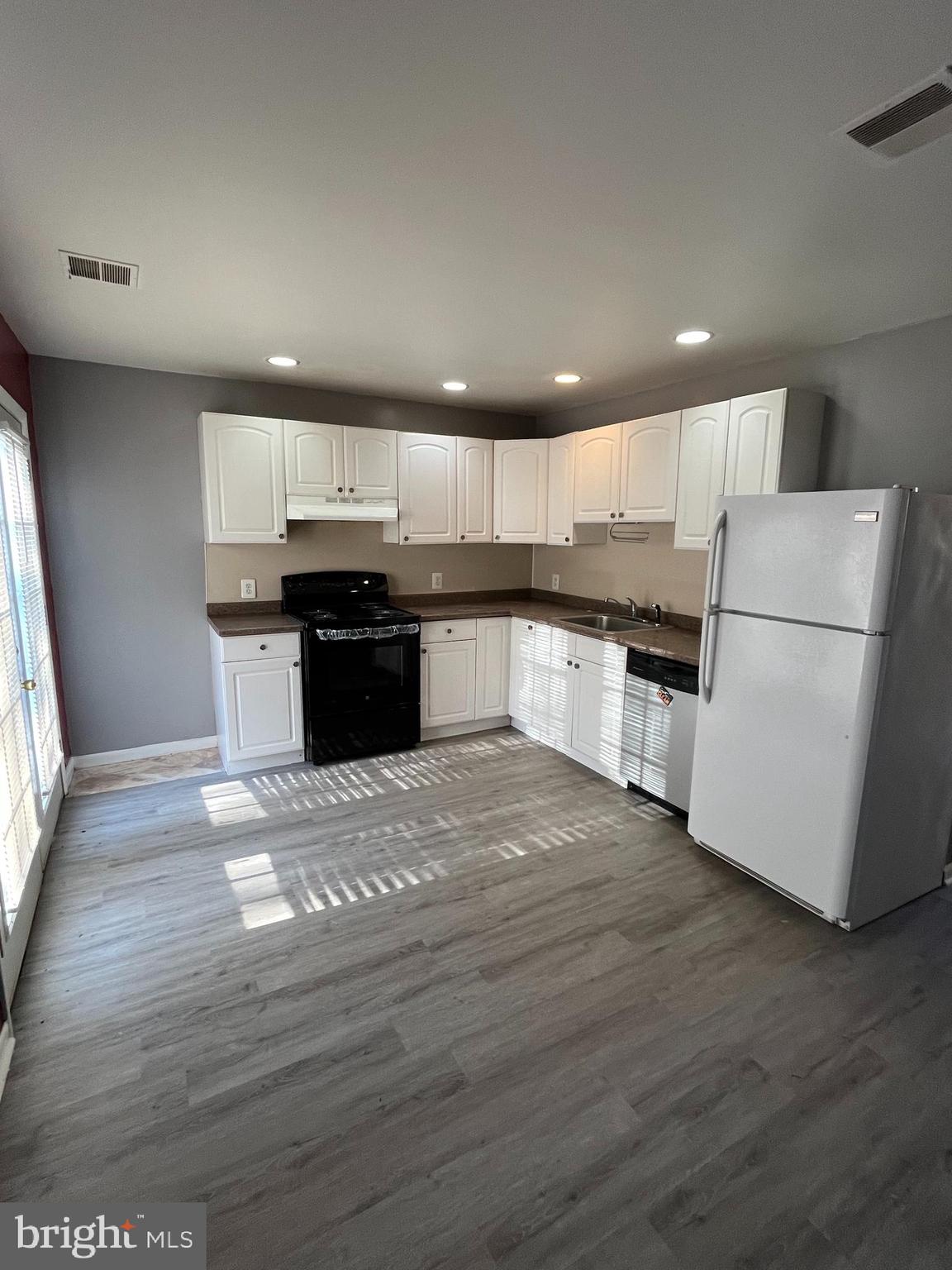 a kitchen with kitchen island wooden floors wooden cabinets and appliances