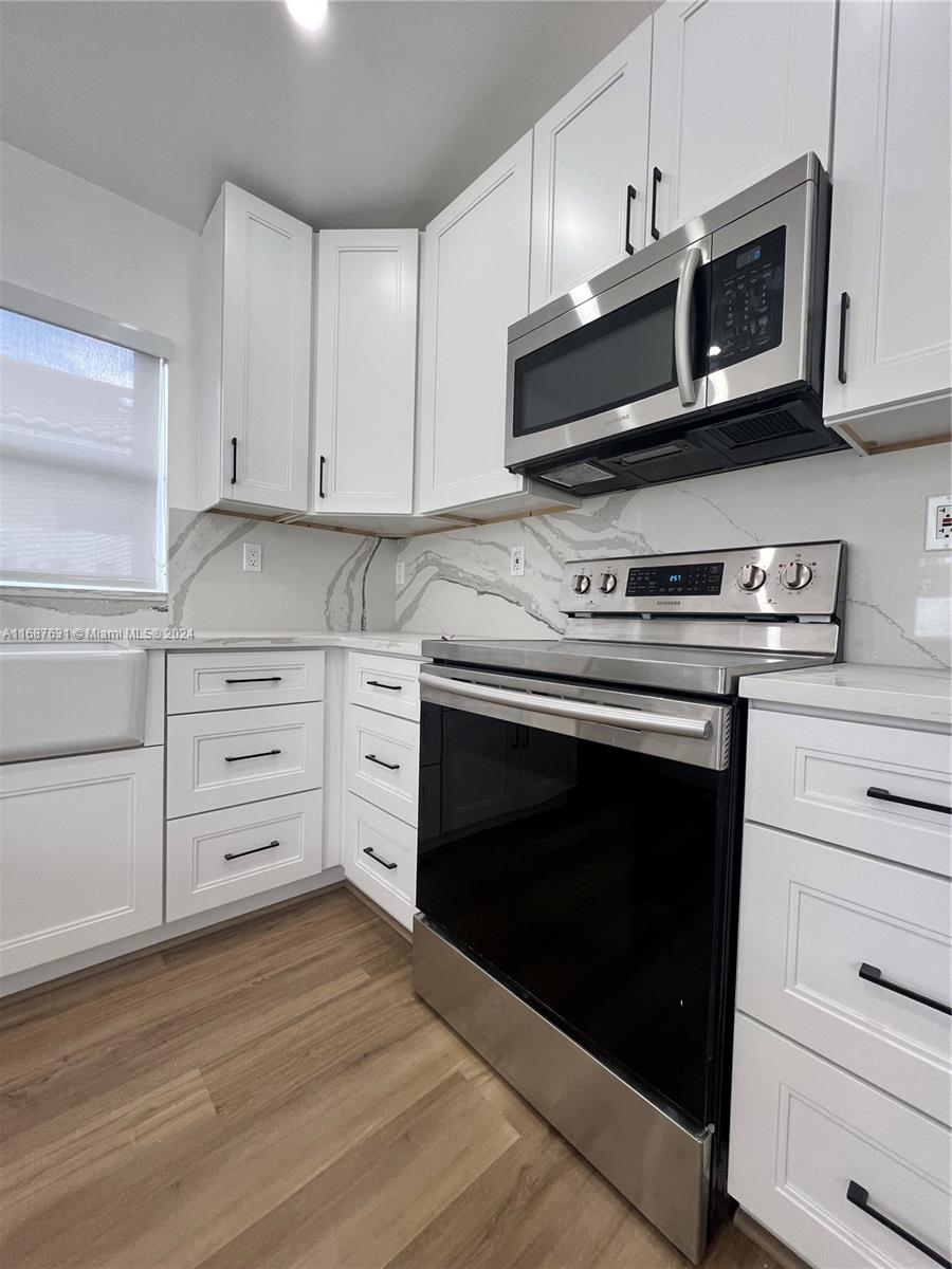 a kitchen with stainless steel appliances granite countertop a stove microwave and cabinets