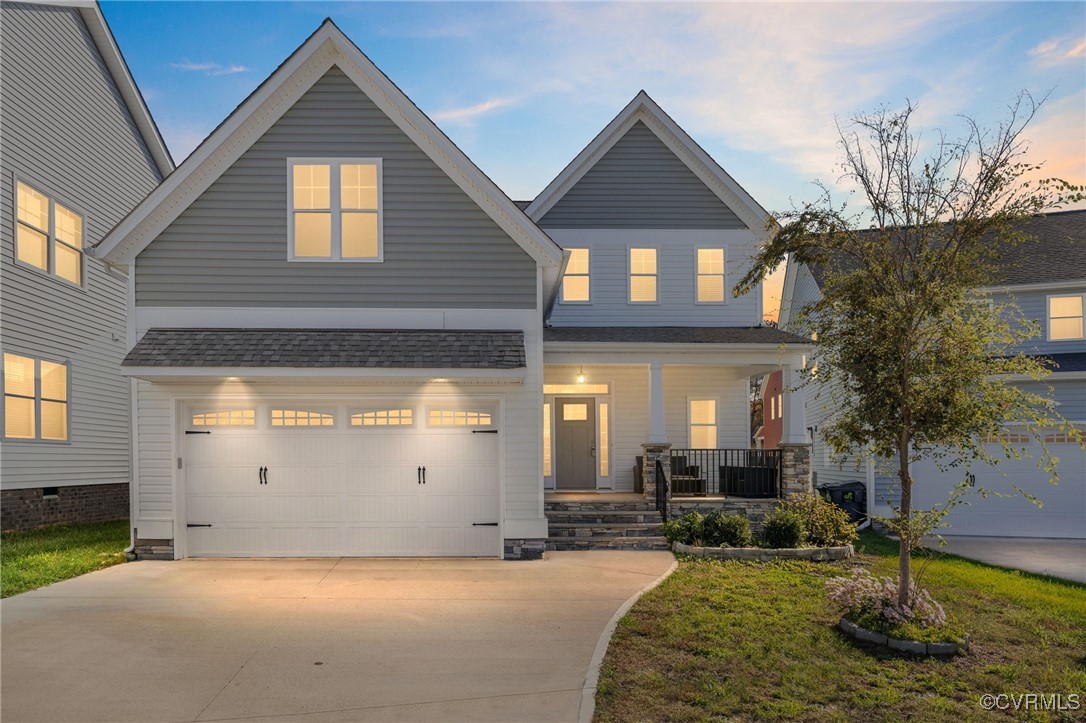 View of front facade with a garage, covered porch,