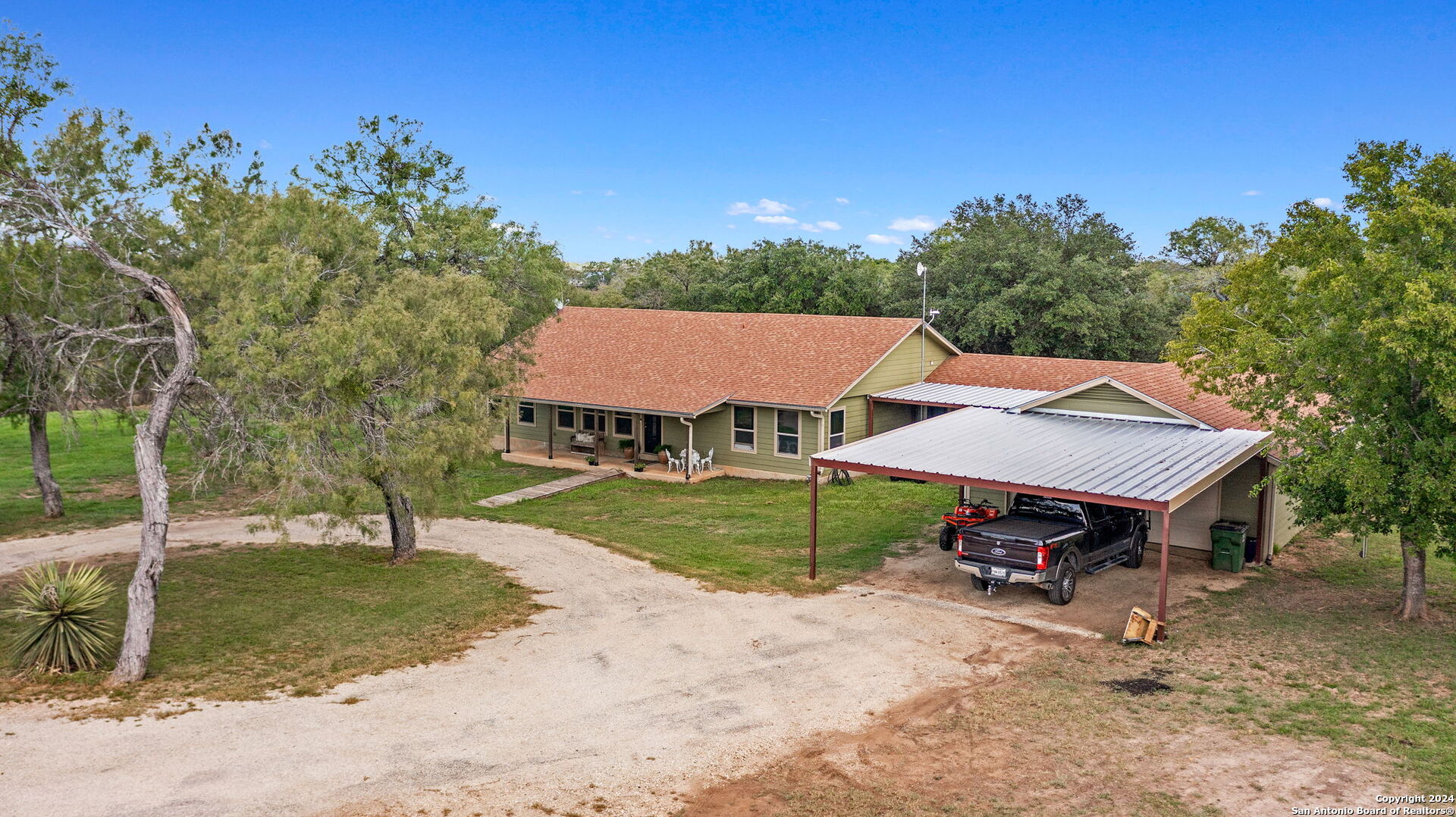 an aerial view of a house with garden space and trees