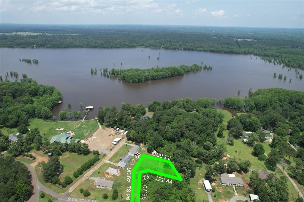 an aerial view of a house with a yard and lake view