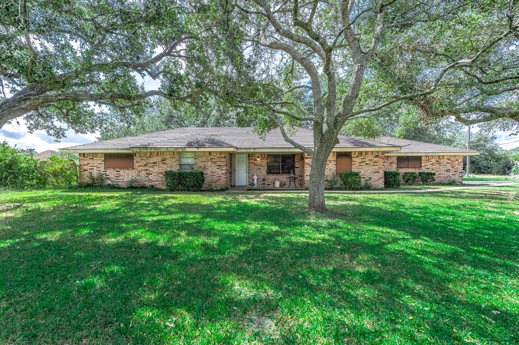 a front view of a house with a yard and trees