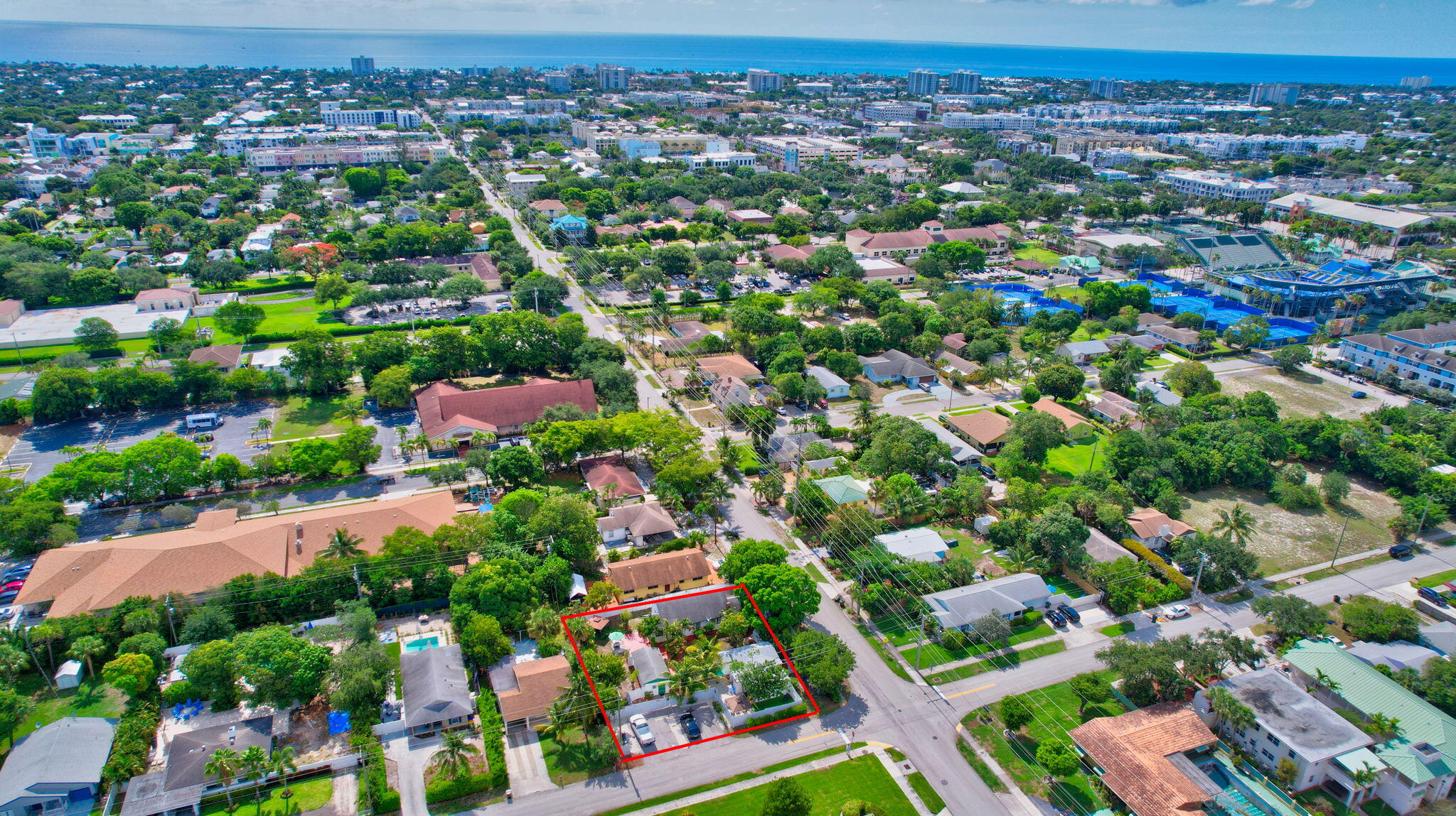 an aerial view of residential houses with outdoor space and trees