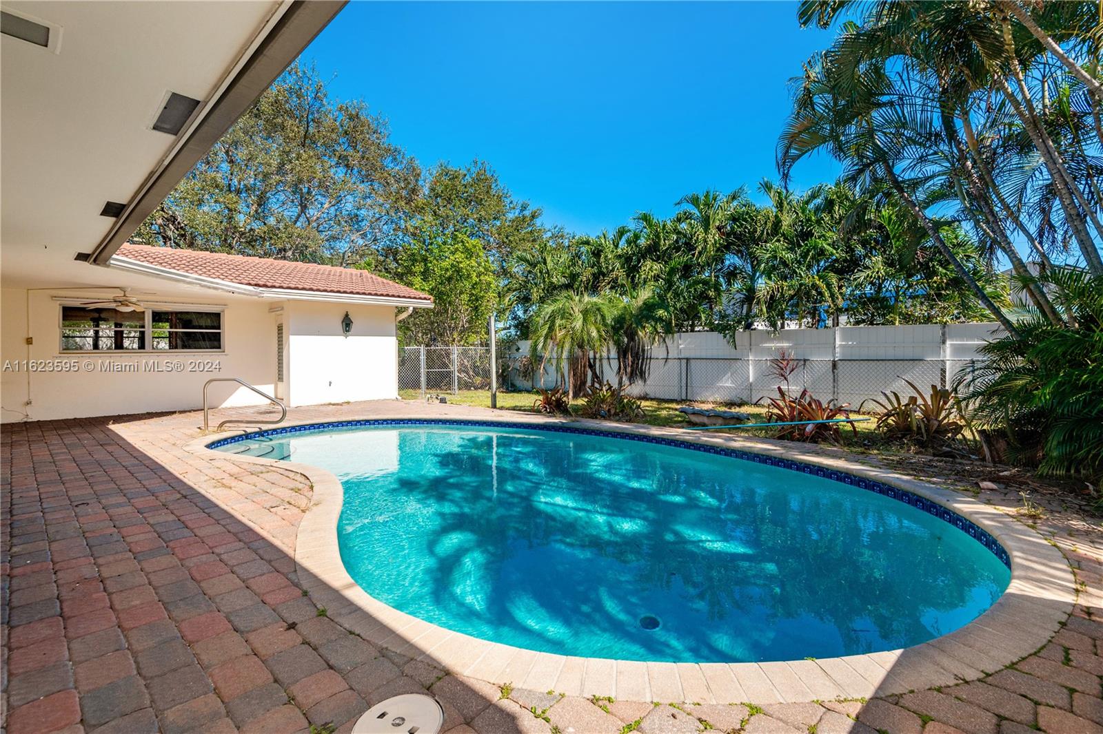 a view of a swimming pool with a yard and plants