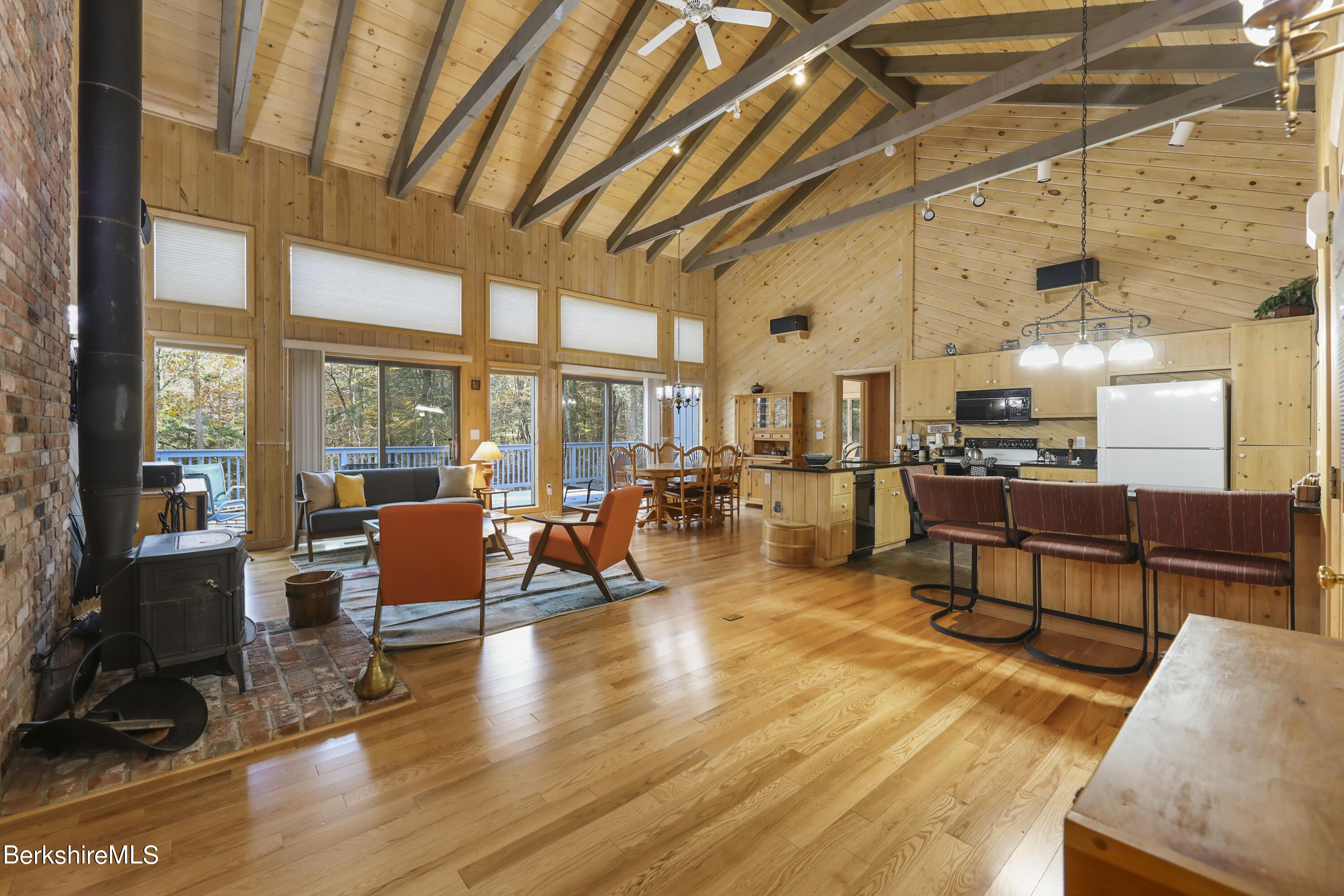 a living room with lots of furniture wooden floor and large windows