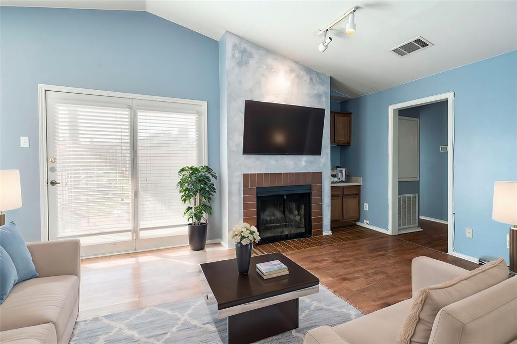 a living room with furniture a flat screen tv and a fireplace