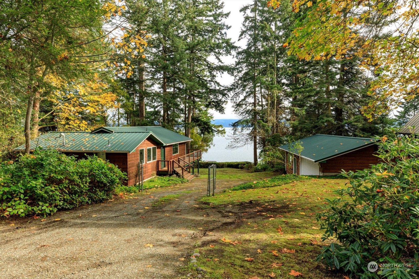 a view of a house with a yard and large trees