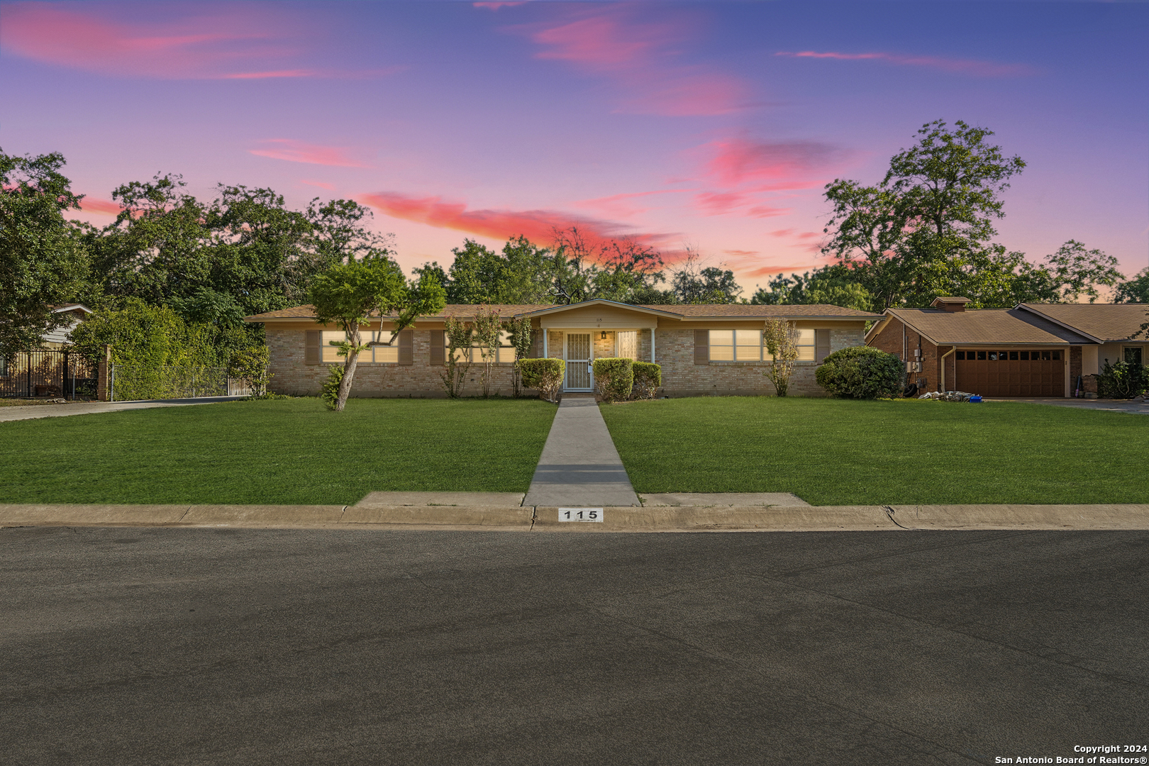 a view of a house with a yard and a street