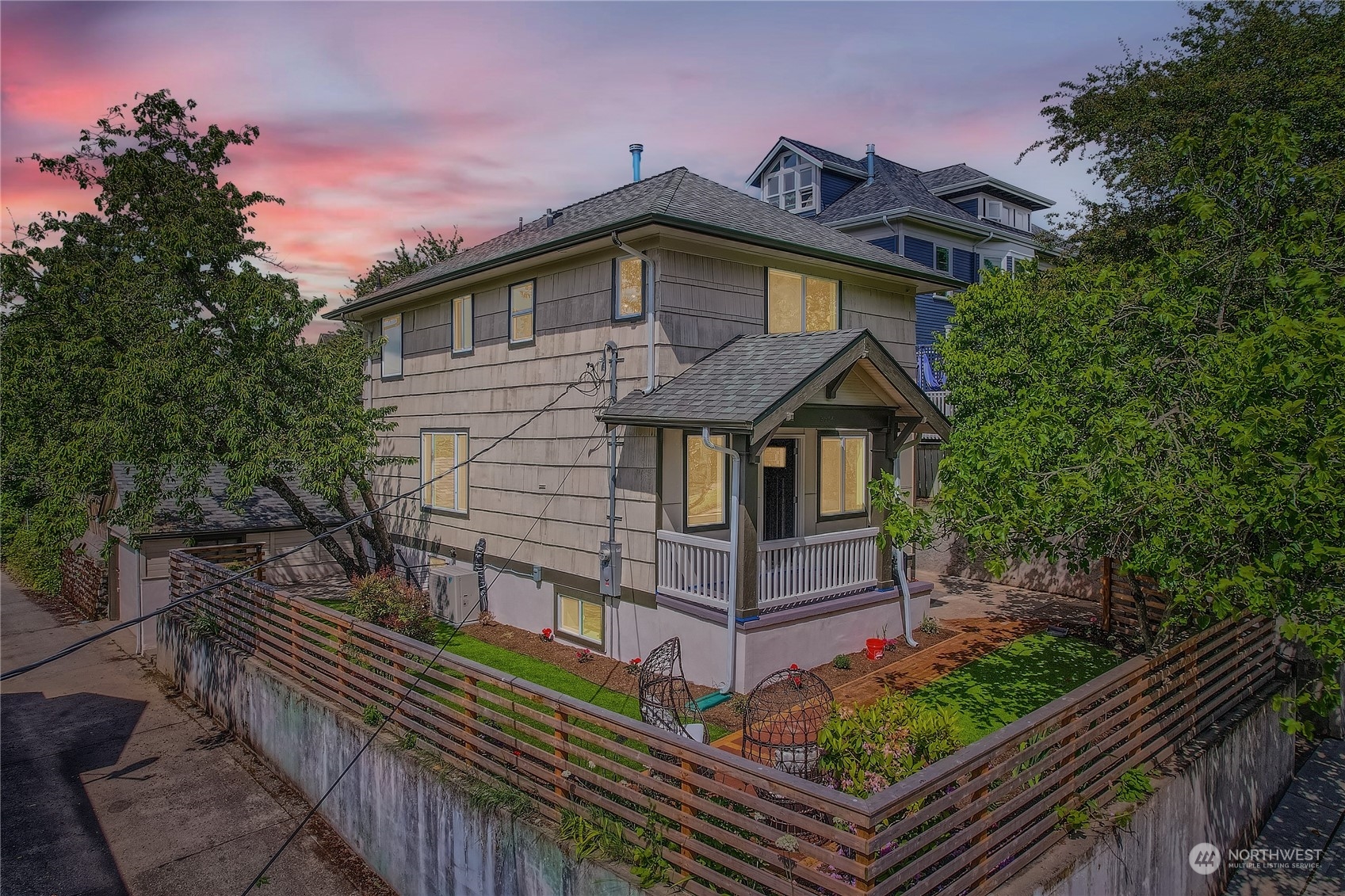 a view of a house with wooden fence next to a yard