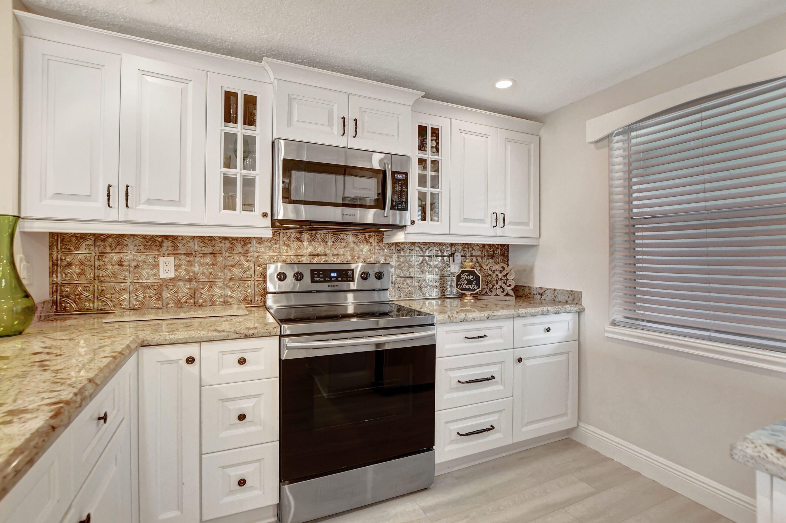 a kitchen with white cabinets sink and stainless steel appliances