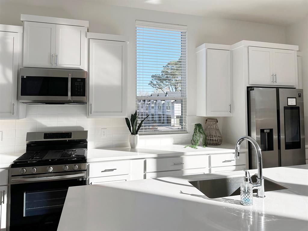 a kitchen with granite countertop a sink and a stove top oven