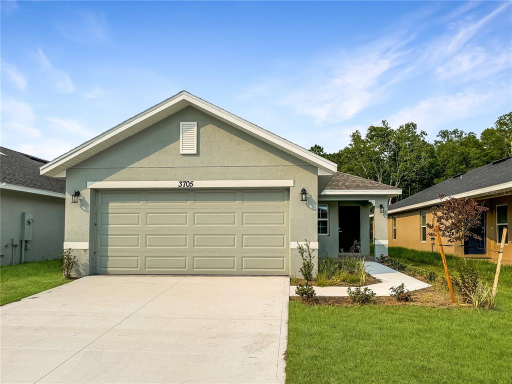 a front view of a house with a yard and garage