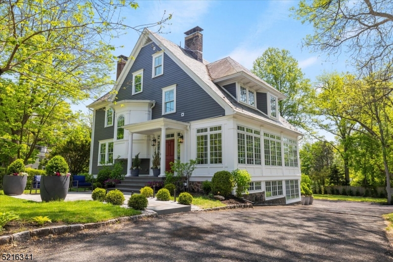 a front view of a house with garden and plants