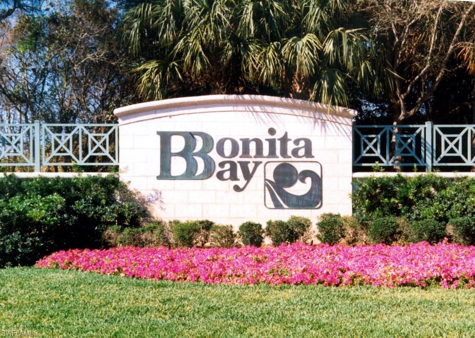 a view of sign board with yard and flowers