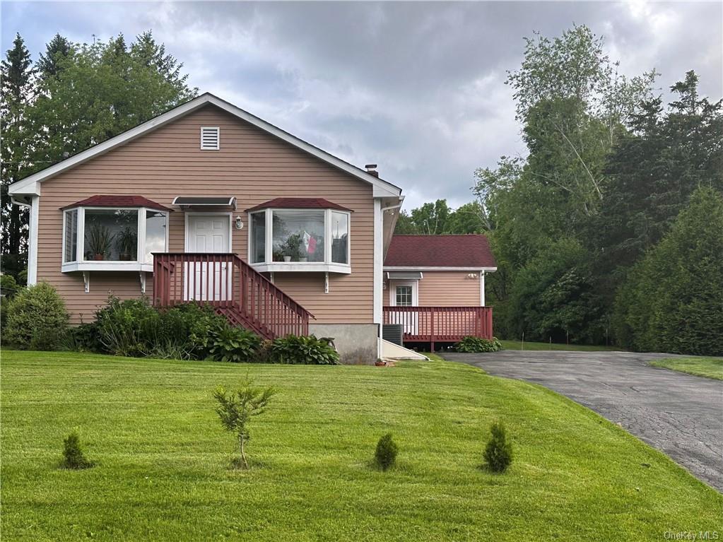 a front view of a house with yard and green space