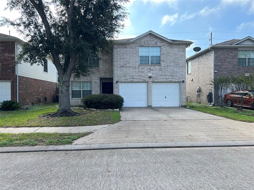 a front view of a house with a yard and a garage