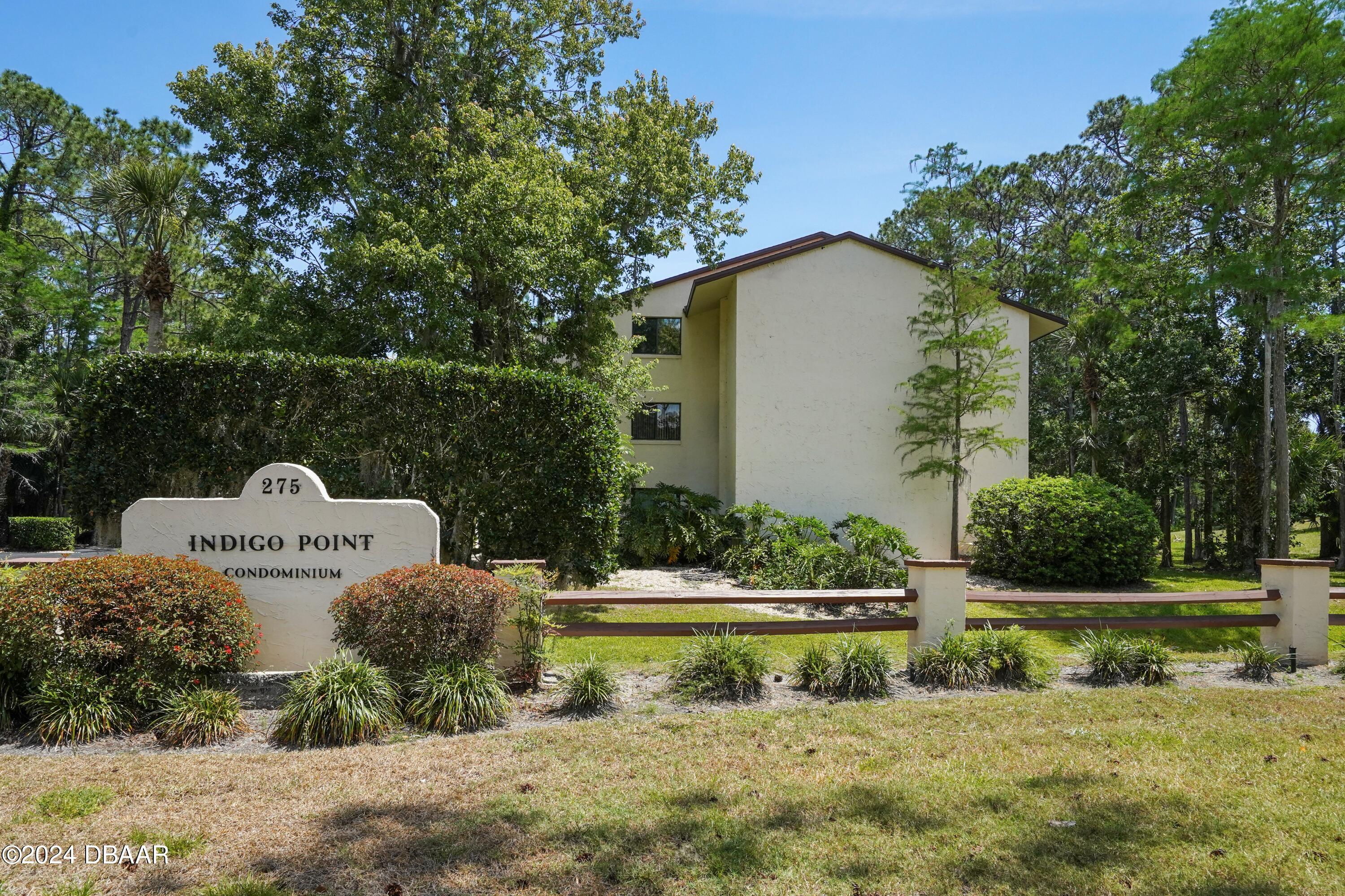 a view of a house with pool plants and big trees