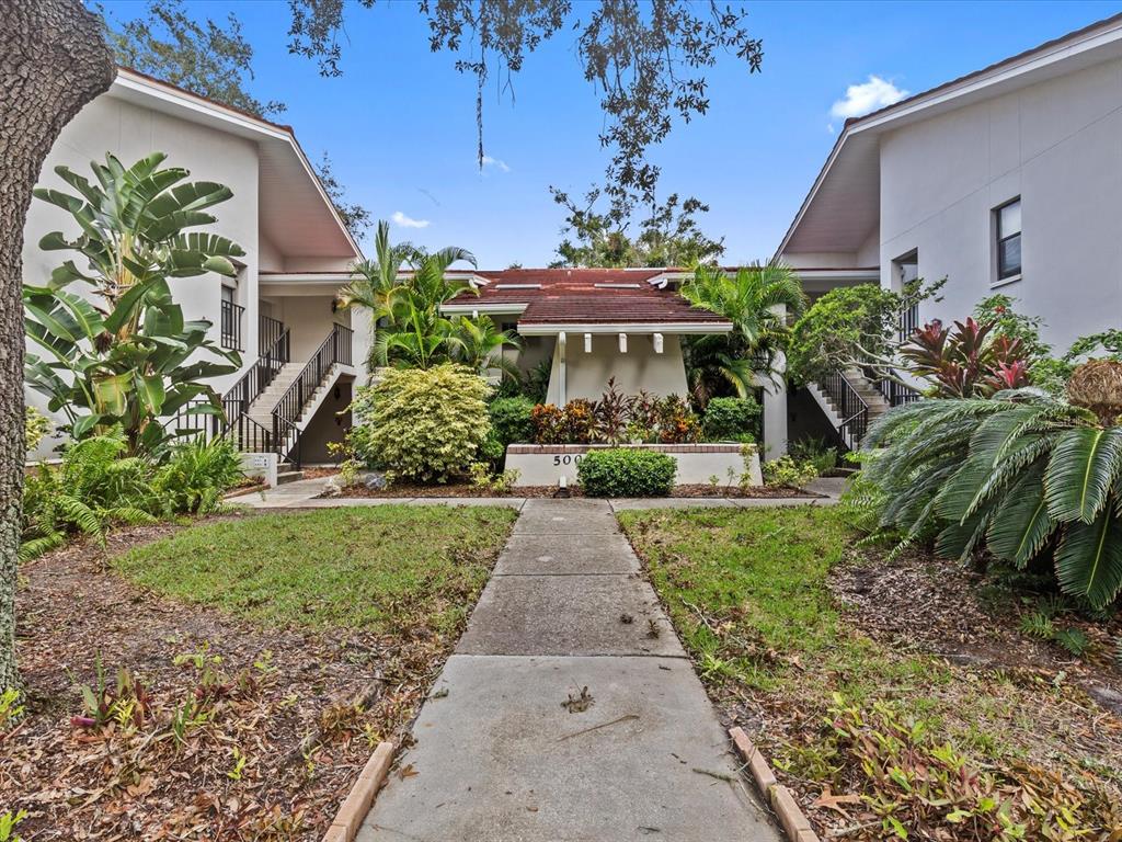 a view of a house with a yard and potted plants