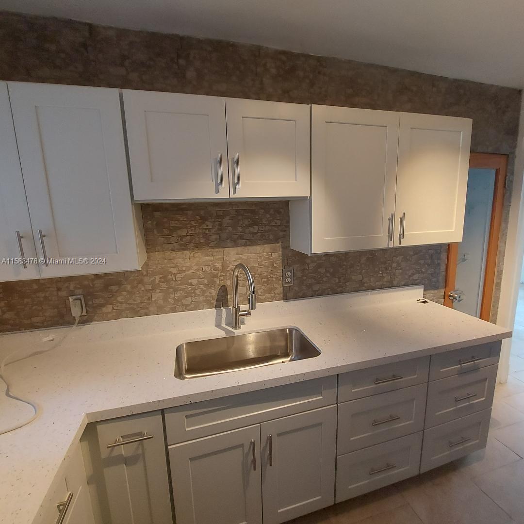 a kitchen with cabinets and white stainless steel appliances