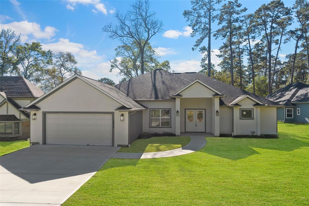 a view of a house with a yard and large tree