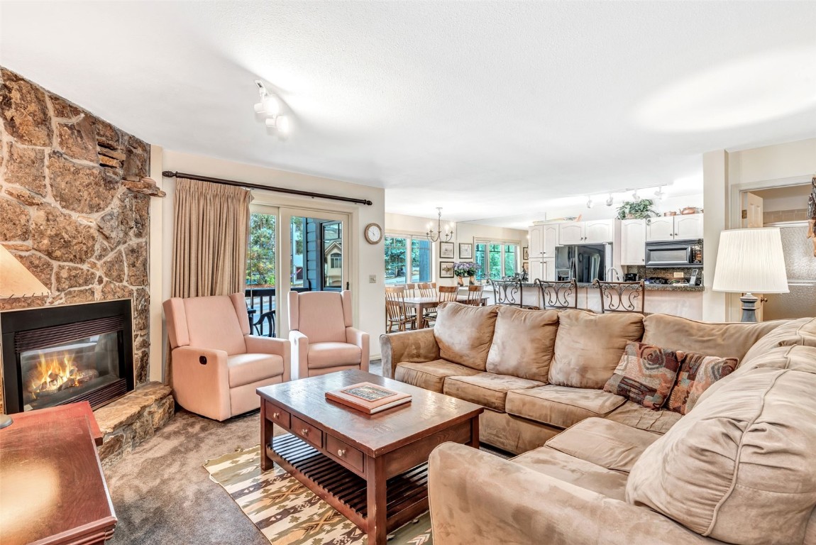 a living room with furniture a fireplace and large windows